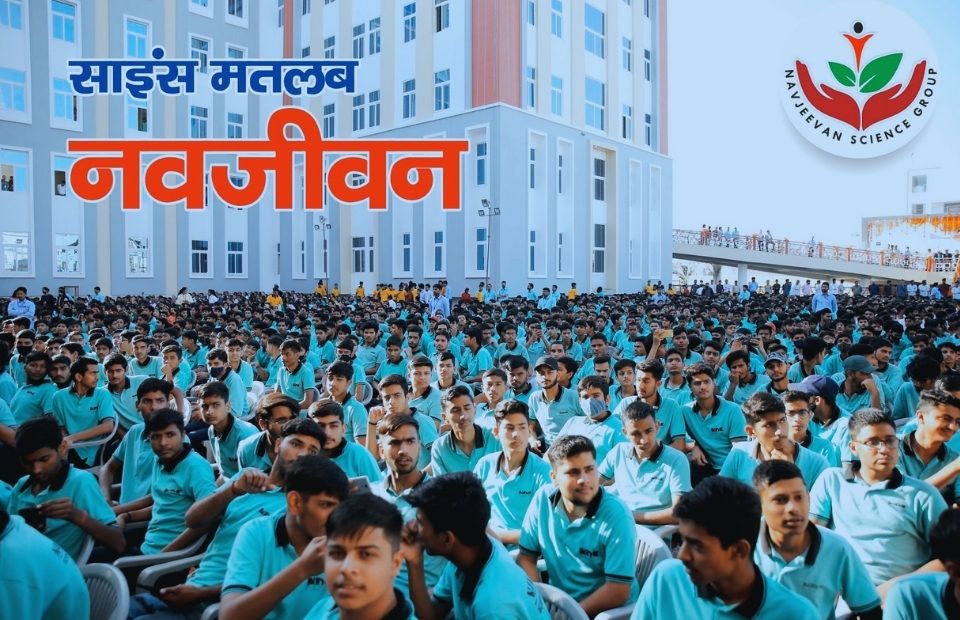 The Navjeevan Science Group (also known as Navjeevan Science School or Navjeevan Shikshan Sansthan) in Sikar captures an inspiring and energetic large-scale assembly scene, with hundreds of uniformed students—mostly boys in matching turquoise-blue shirts and attire—seated closely in orderly rows on the open ground, attentively facing forward as part of a motivational or motivational gathering focused on "Science Means Navjeevan" (Science Means New Life). In the background stands a tall, modern multi-storey academic building with a sleek facade in alternating light grey and white panels accented by warm peach-orange vertical stripes, large windows, and a bridge-like walkway or elevated corridor on the upper level where a few figures are visible. The massive crowd fills the foreground under a bright sky, with students in various poses—some raising hands, others engaged in discussion or looking attentive—creating a vibrant atmosphere of discipline, ambition, and collective drive toward science education, competitive exams like IIT-JEE/NEET, and holistic growth. The overlaid Hindi text "साइंस मतलब नवजीवन" in bold blue and orange, along with the Navjeevan Group logo featuring a stylized hand and leaf motif, emphasizes the institution's motto of renewal through knowledge, set against the expansive, well-maintained campus environment that reflects its reputation as a leading science-focused educational hub in Sikar with strong results and student motivation.