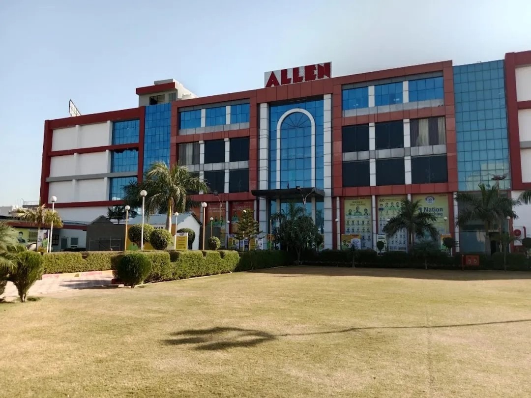 The iconic red-and-blue ALLEN Career Institute campus in Sikar (as shown in your image of the multi-story building with prominent ALLEN branding, arched entrance, and surrounding greenery) represents one of the premier destinations for JEE preparation, backed by the institute's national legacy and strong local performance in recent years. In JEE Main 2025, ALLEN Sikar delivered outstanding results, including Sikar topper Jay Agarwal with AIR 91 (overall), multiple students securing 99.9+ percentiles (e.g., 7 in top brackets for one session), 32+ classroom students above 99.5%ile in Session-1, and solid qualifiers in top AIR ranges like under 2000 and 5000. For JEE Advanced 2025, it shone with high ranks such as Vipul Sihag (AIR 114), Jay Agarwal (AIR 126), Vishesh Charan (AIR 267), 3 students in top 300 AIR, and 10 in top 2000 AIR, reinforcing its reputation for producing top-tier IIT qualifiers through experienced faculty, structured programs, rigorous testing, and a disciplined ecosystem. While emerging Sikar institutes like Matrix often lead in certain mass selection metrics (e.g., higher number of 99+ percentiles or qualifiers in some analyses), ALLEN Sikar stands as a clear, reliable choice for aspirants seeking proven national-level guidance, consistent high ranks, and a brand trusted for decades, making its impressive campus a hub for serious JEE 2026 hopefuls aiming for top IITs in a competitive yet supportive environment.